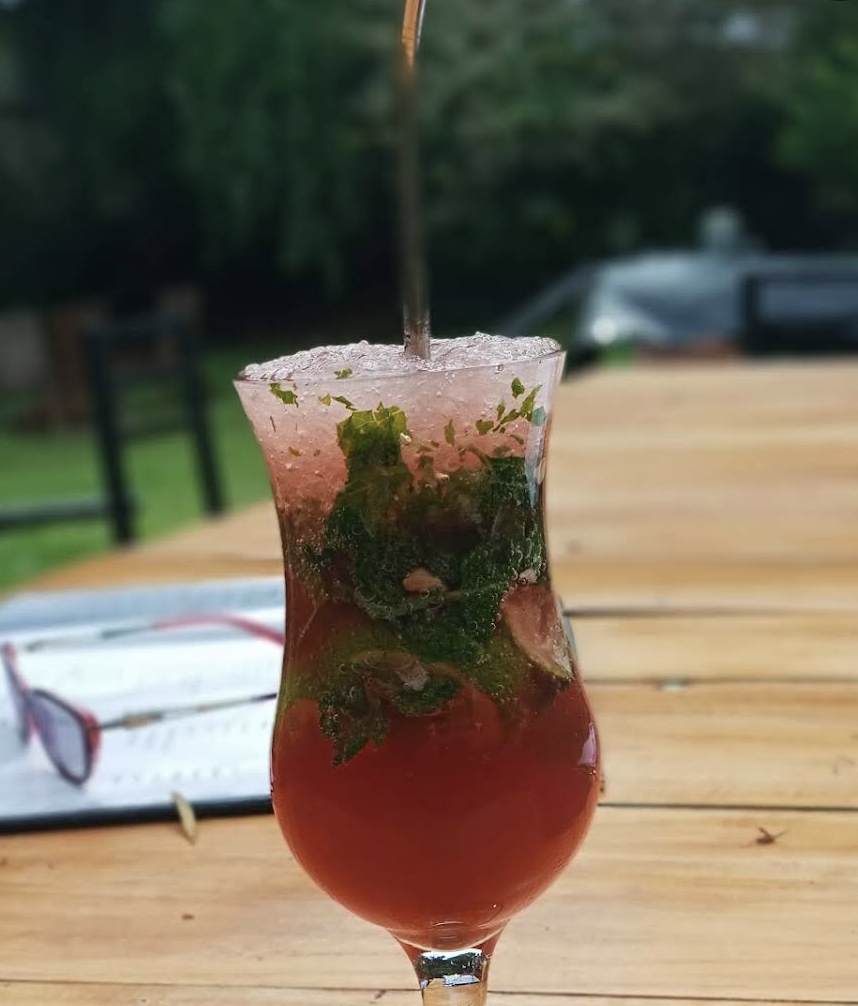Berry mint cocktail on a garden table at Orchid